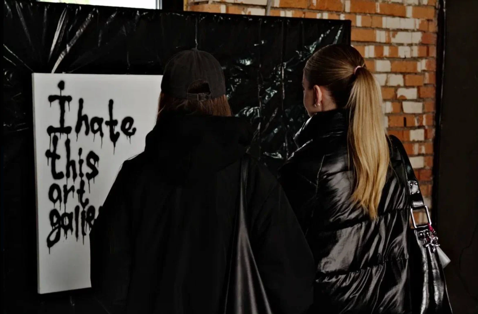 Visitors beside an expressive lettering artwork at B-Walls